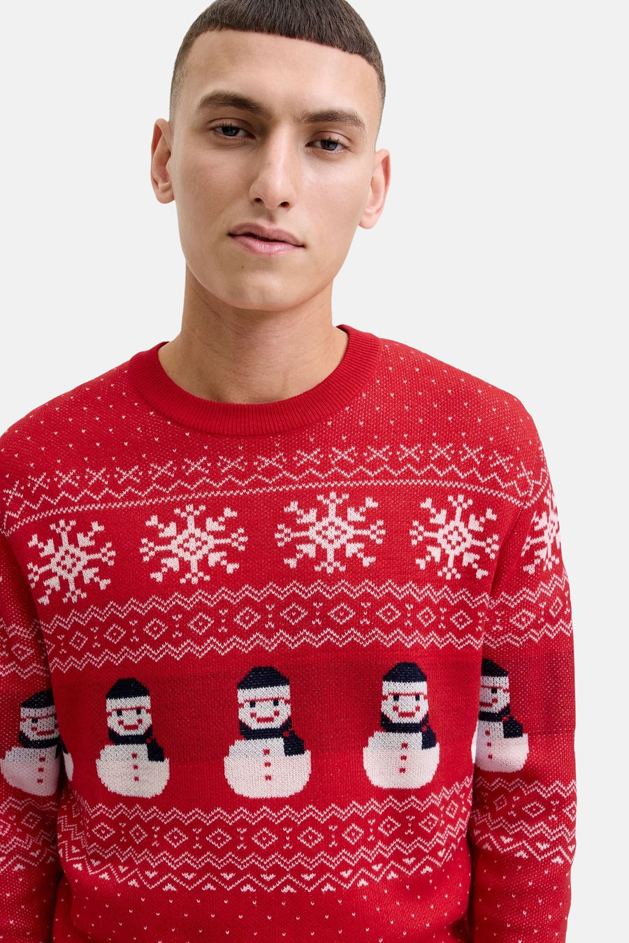 Pull rouge à col rond de JACK & JONES avec motifs de flocons de neige et bonhommes de neige.