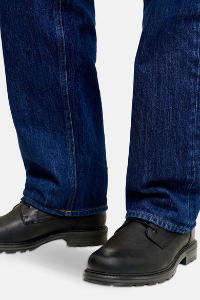 Bottines noires en cuir de ACCESSORIES BY JACK & JONES, portées avec un jean bleu foncé.