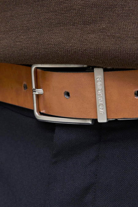 Bruine riem van ACCESSORIES BY JACK & JONES, zilveren gesp, gedragen met een bruine trui en een marineblauwe broek.