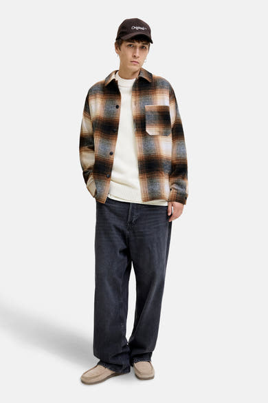 Bruin geruit overhemd met lange mouwen van JACK & JONES, gedragen over een crèmekleurige trui en een wijde zwarte jeans.