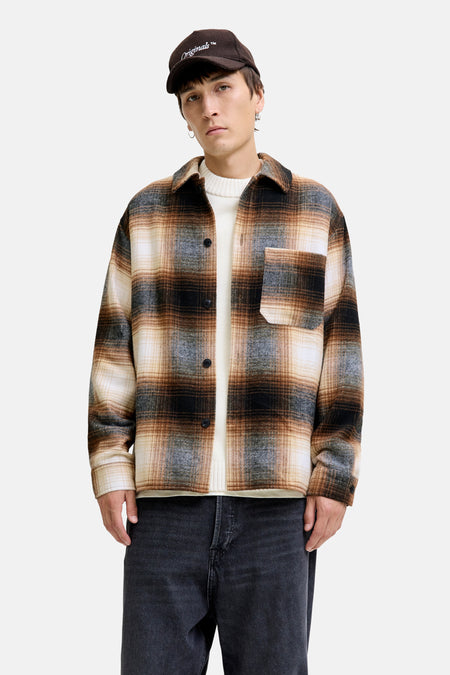 Bruin overhemd met lange mouwen van JACK & JONES, geruit, gedragen over een witte trui en een zwarte broek.