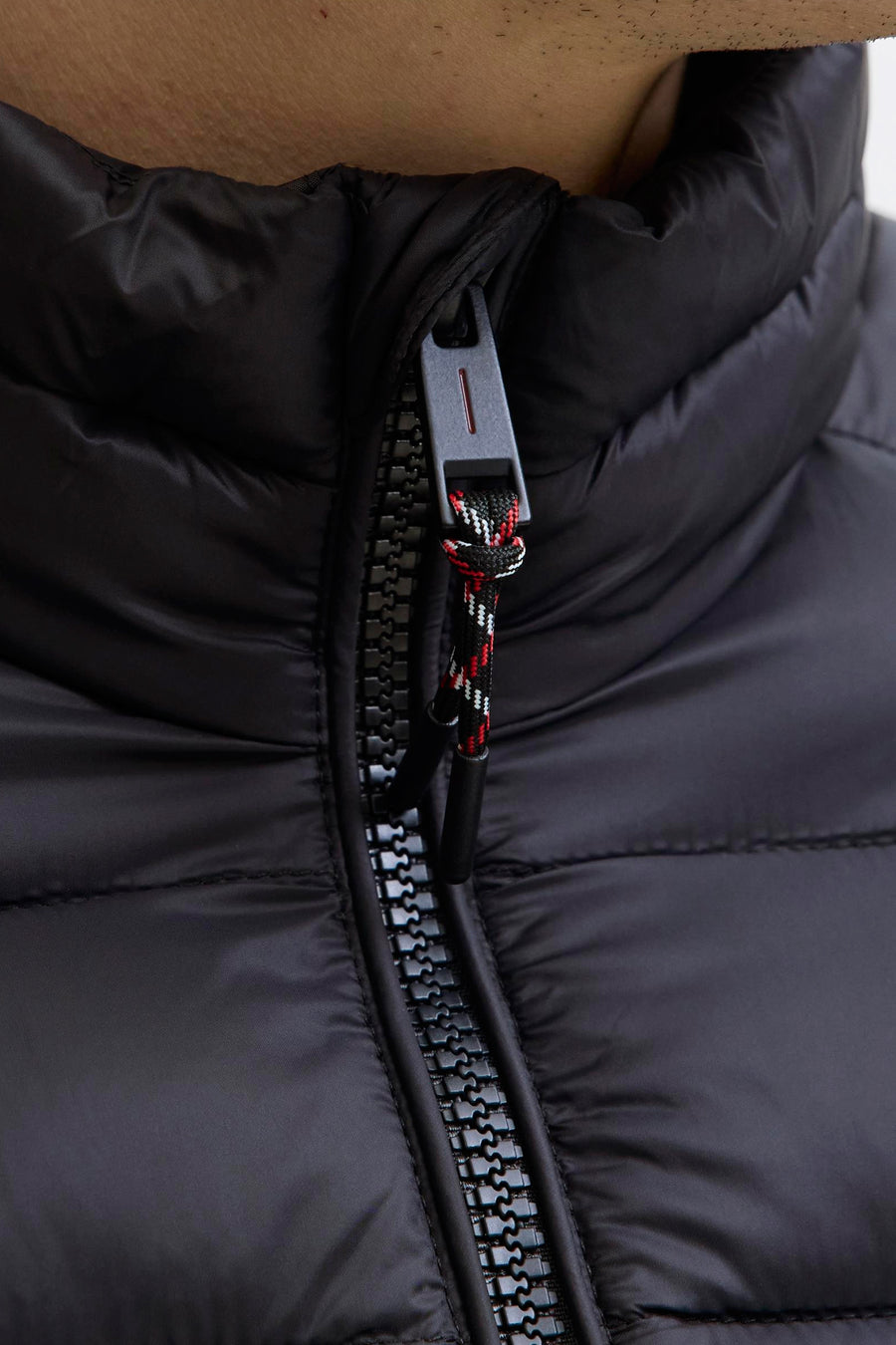 Veste de pluie noire par JACK & JONES, avec fermeture éclair et détails texturés.