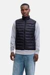 Veste sans manches noire de JACK & JONES, portée sur un pull gris et un jean bleu.