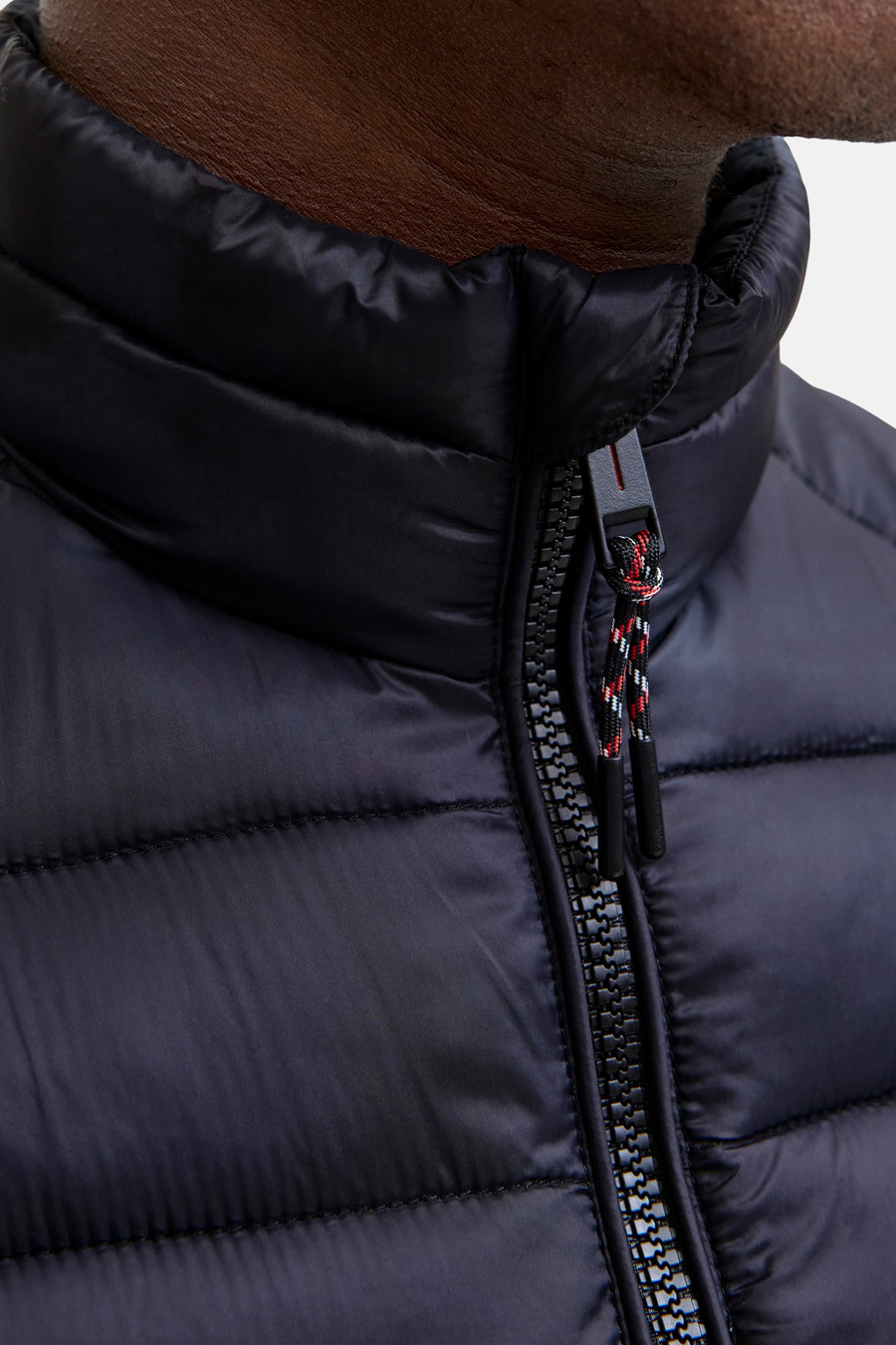 Veste sans manches noire de JACK & JONES avec fermeture éclair visible et col montant.
