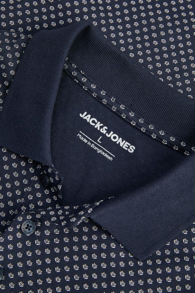 Polo bleu marine à motifs, de JACK & JONES, avec col en maille côtelée et étiquette apparente.
