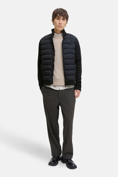 Blauwe jas van PREMIUM by JACK & JONES, gedragen over een gestreept overhemd en een beige gebreide trui.