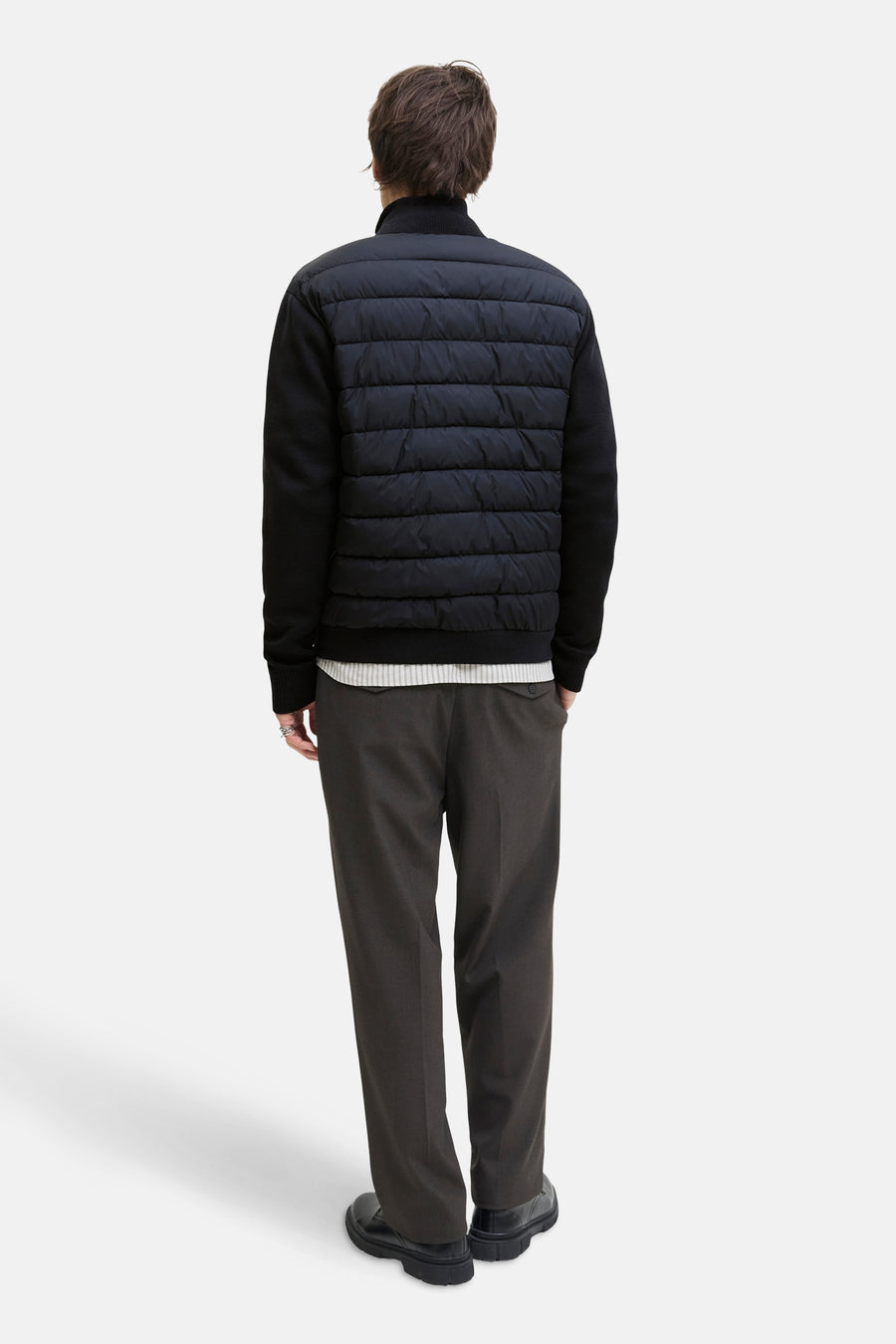 Blauwe jas van PREMIUM by JACK & JONES, gewatteerd aan de voorkant, gedragen met een grijze broek en zwarte schoenen.
