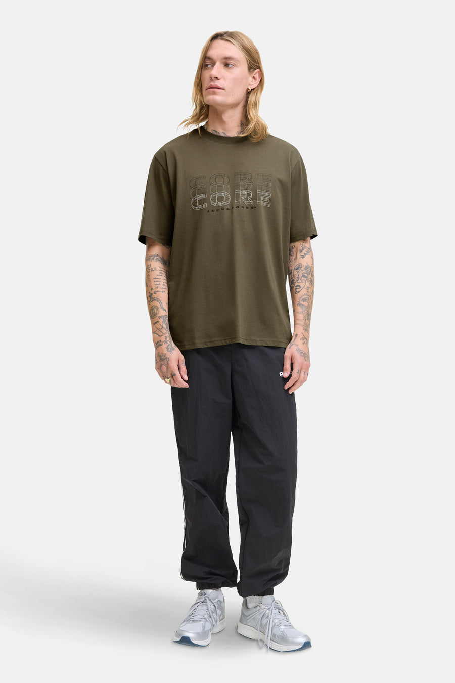 Groen T-shirt met korte mouwen van JACK & JONES, met 'Core'-opdruk op de voorkant, gedragen met een zwarte joggingbroek.