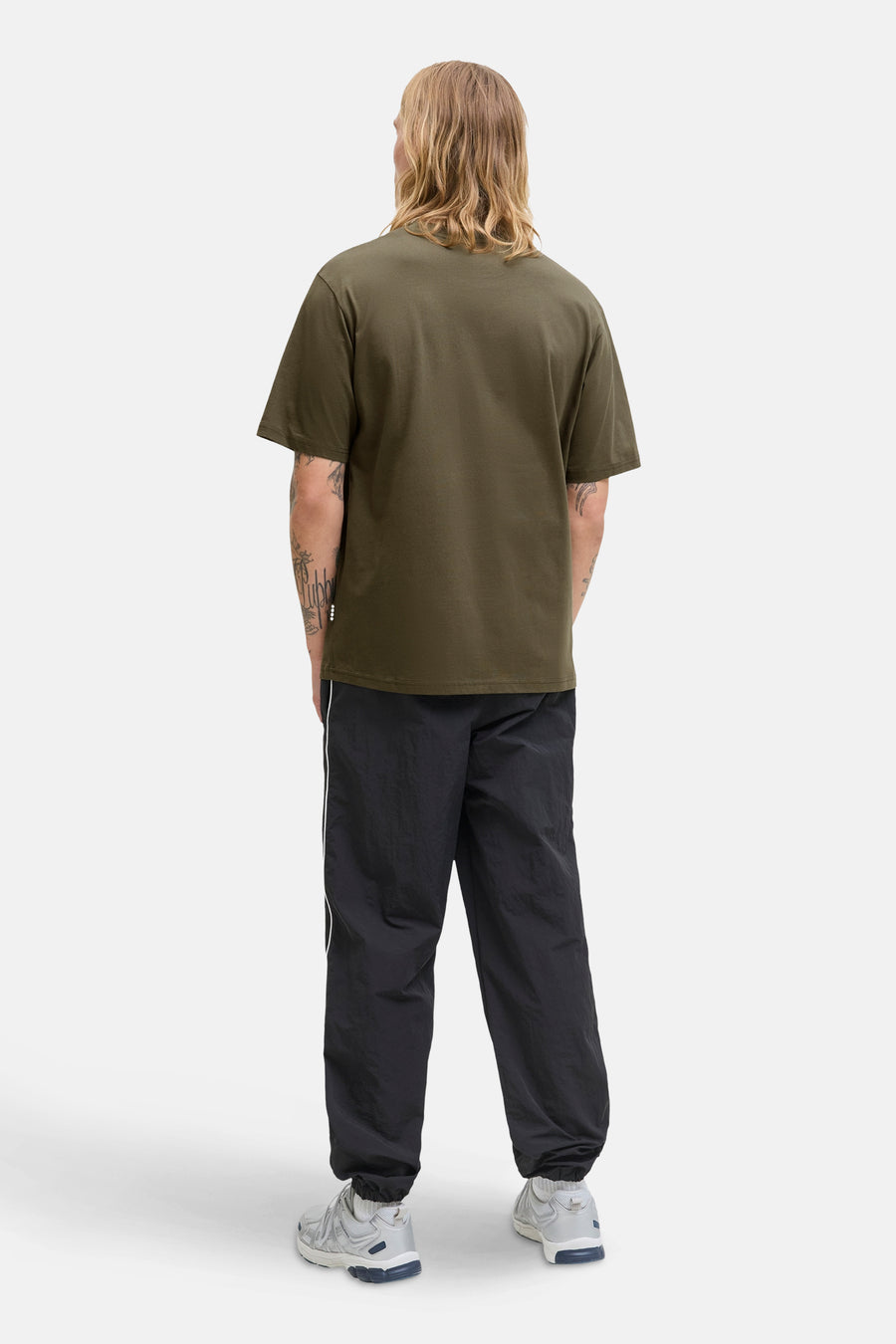 Olijfgroen T-shirt met korte mouwen van Jack & Jones, gedragen met een zwarte broek en sneakers.
