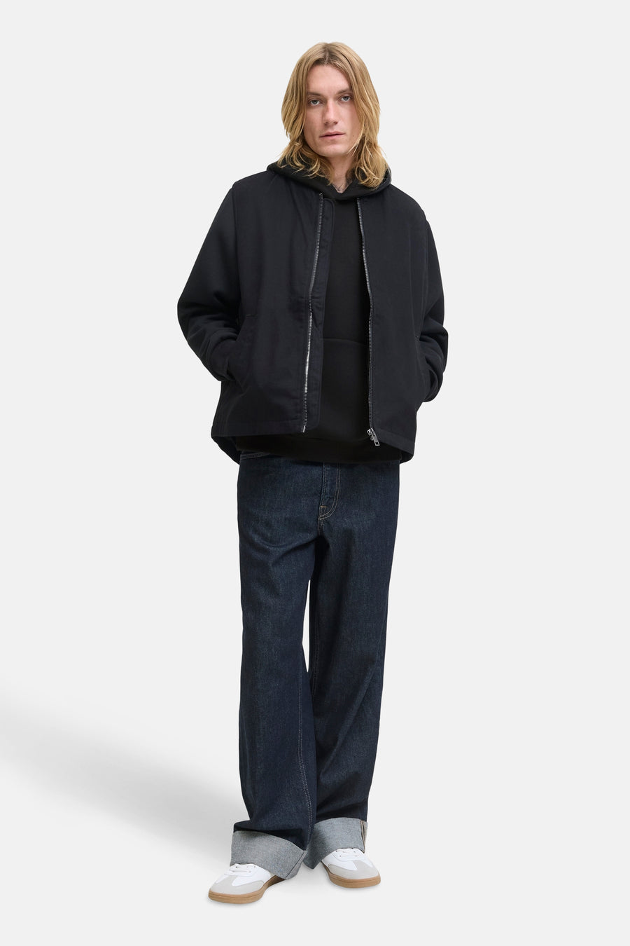 Zwarte hoodie van JACK & JONES, gedragen over een ritsjack, met een wijde jeans.