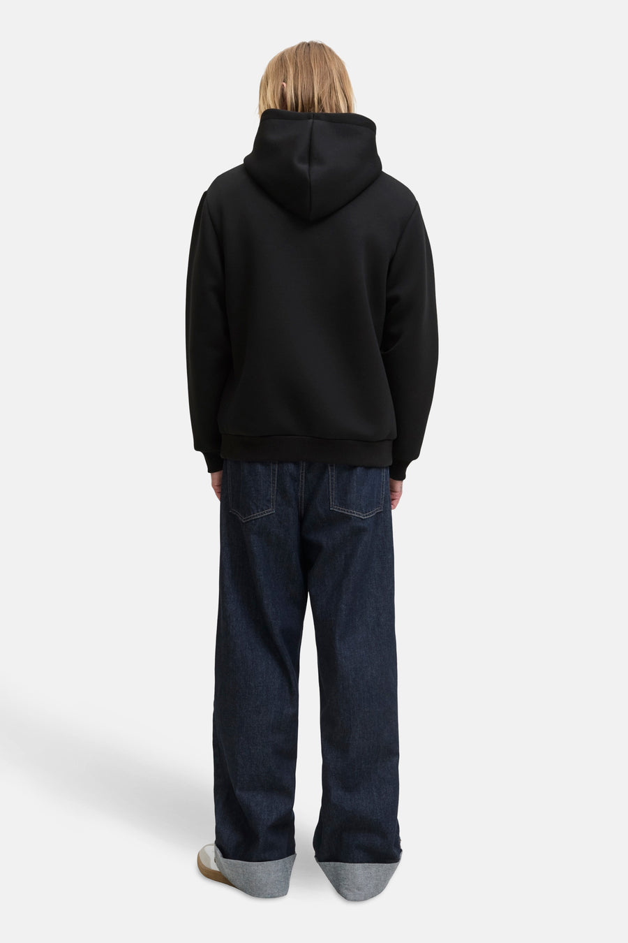 Zwarte hoodie van JACK & JONES, gedragen met een wijde jeans en sneakers.