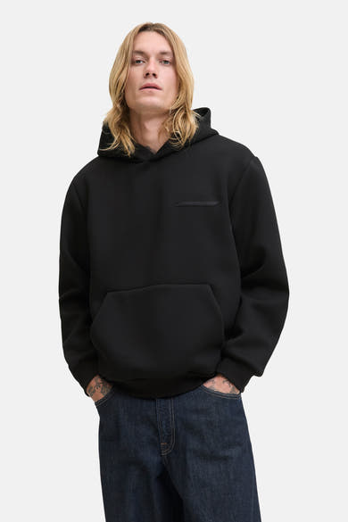Zwarte hoodie van JACK & JONES, met een kangoeroezak en een decoratieve patch op de borst.
