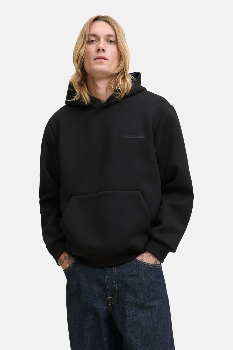 Zwarte hoodie van JACK & JONES, met een kangoeroezak en een decoratieve patch op de borst.