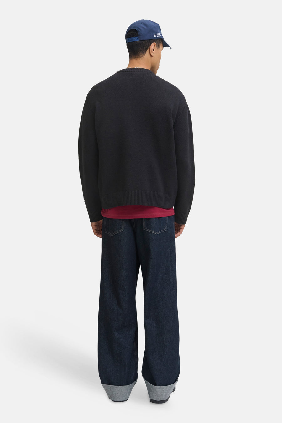 Pull à col rond noir par ORIGINALS BY JACK & JONES, porté avec un t-shirt rouge et un pantalon en denim ample, vue arrière.