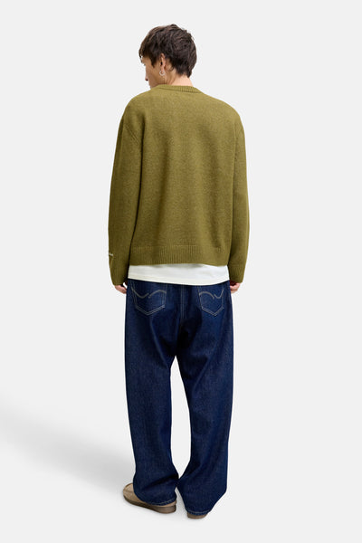 Groene trui met ronde hals van ORIGINALS BY JACK & JONES, gedragen met een wit T-shirt en een wijde jeans.