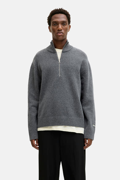 Pull col rond gris par ORIGINALS BY JACK & JONES avec fermeture éclair et porté avec un pantalon noir.