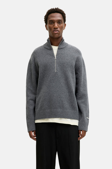 Ronde hals grijze trui van ORIGINALS BY JACK & JONES met ritssluiting en gedragen met een zwarte broek.