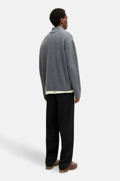 Pull à col rond gris de ORIGINALS BY JACK & JONES porté avec un pantalon noir ample et des chaussures bateau marron.