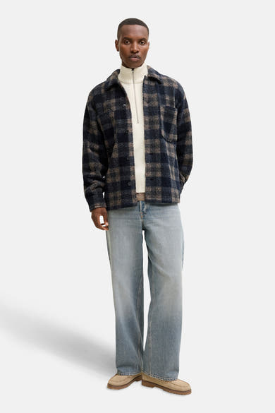 Ecru ronde hals trui van ORIGINALS BY JACK & JONES, gedragen met een geruit overhemd en een verbleekte jeans.