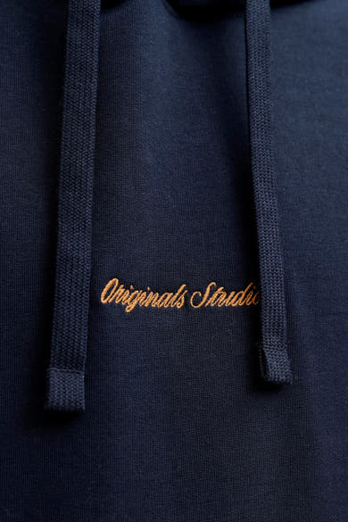 Blauwe hoodie van PREMIUM by JACK & JONES, met koorden en okerkleurig geborduurd logo.