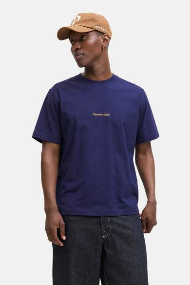 Blauw T-shirt met korte mouwen van ORIGINALS BY JACK & JONES, gedragen met een beige pet en een spijkerbroek.