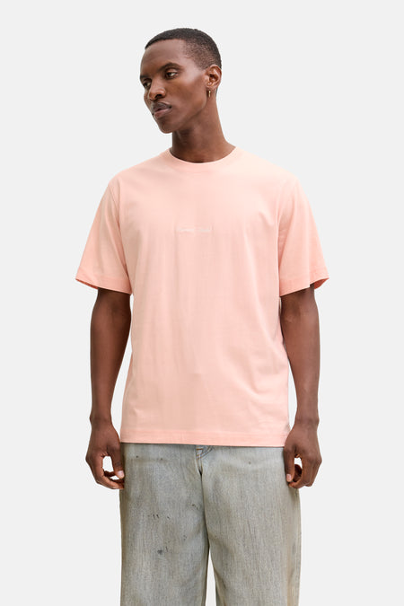 Roze T-shirt met korte mouwen van ORIGINALS BY JACK & JONES, gedragen met een wijde jeans en sneakers.