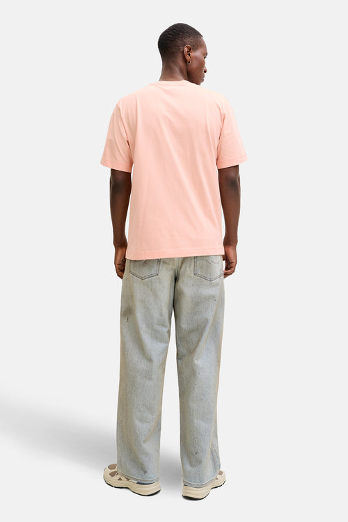 T-shirt à manches courtes rose par ORIGINALS BY JACK & JONES, porté avec un jean ample et des baskets.