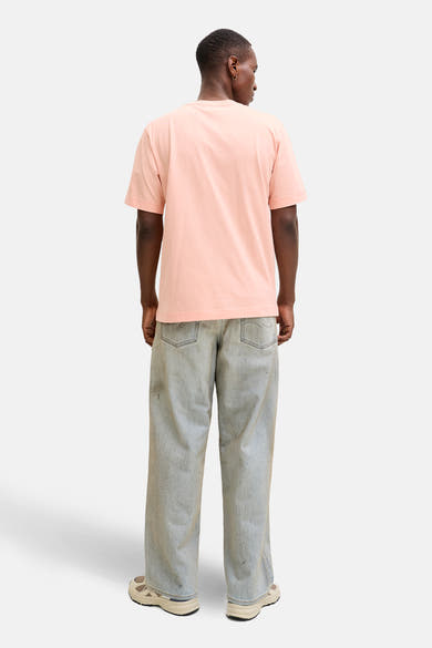 T-shirt à manches courtes rose par ORIGINALS BY JACK & JONES, porté avec un jean ample et des baskets.