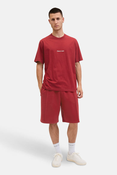 Rood T-shirt met korte mouwen van ORIGINALS BY JACK & JONES, gedragen met een bijpassende korte broek en witte sneakers.