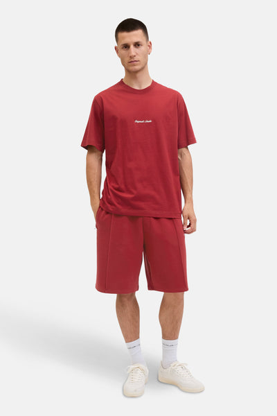 Rood T-shirt met korte mouwen van ORIGINALS BY JACK & JONES, gedragen met een bijpassende korte broek en witte sneakers.