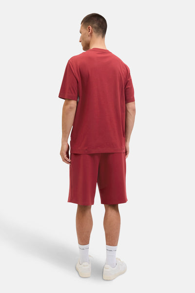 Rood T-shirt met korte mouwen van ORIGINALS BY JACK & JONES, gedragen met een bijpassende korte broek en witte sneakers.