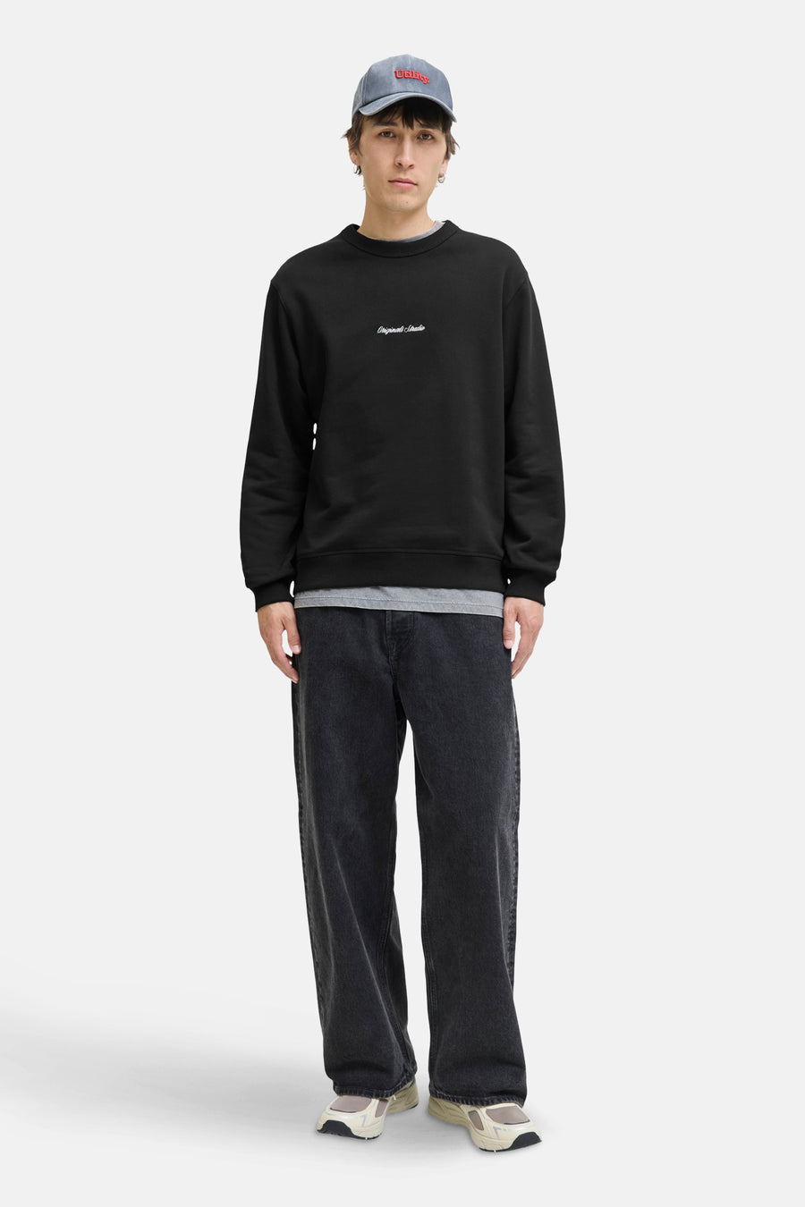 Zwarte rondehals sweatshirt van ORIGINALS BY JACK & JONES, gedragen met een grijs T-shirt, een wijde zwarte jeans en sneakers.