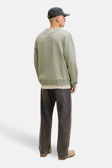 Groene rondehals sweatshirt van ORIGINALS BY JACK & JONES, gedragen met een T-shirt en een donkergrijze jeans.
