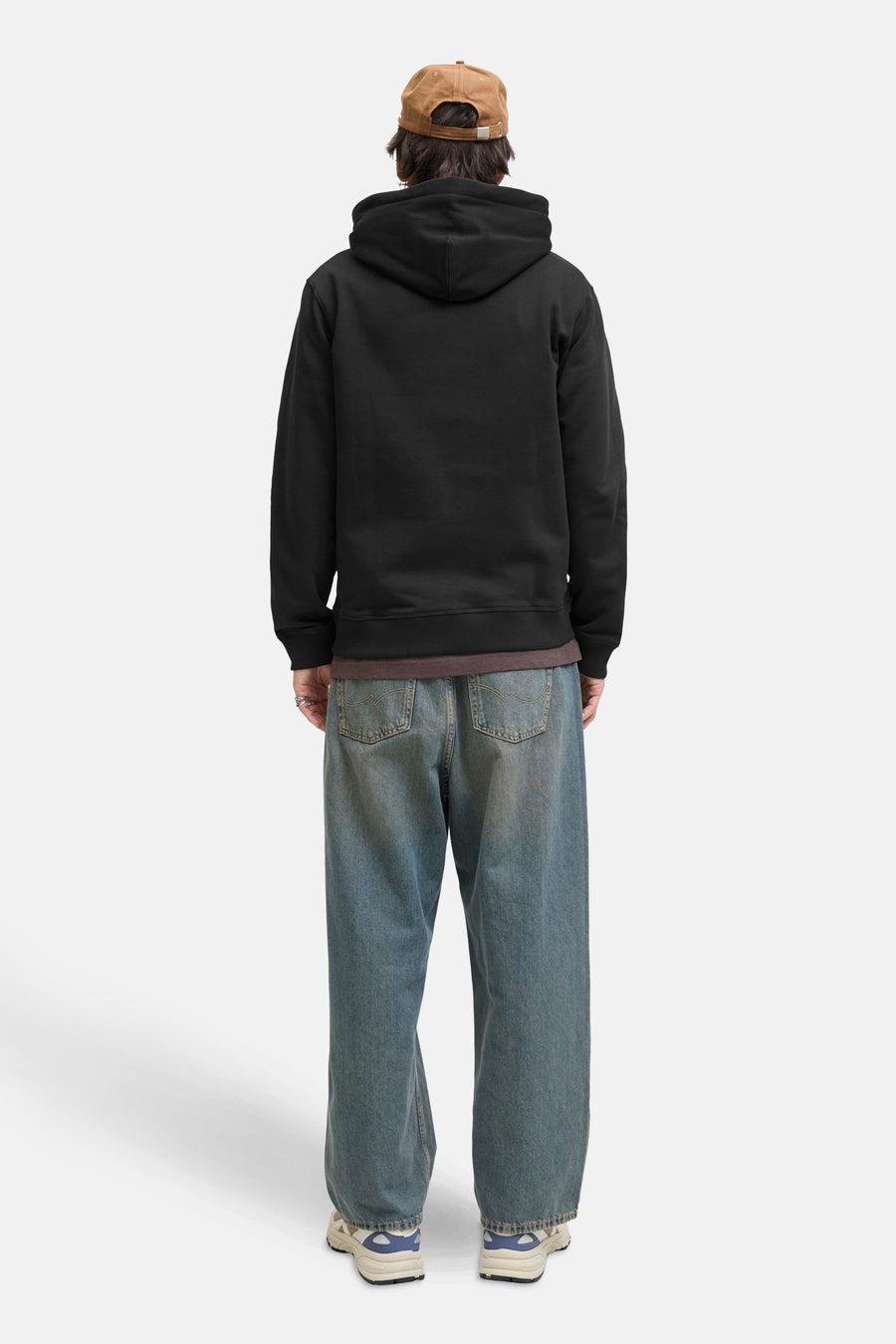 Zwarte zip-hoodie, PREMIUM by JACK & JONES, gedragen met een wijde blauwe jeans en crèmekleurige sneakers.