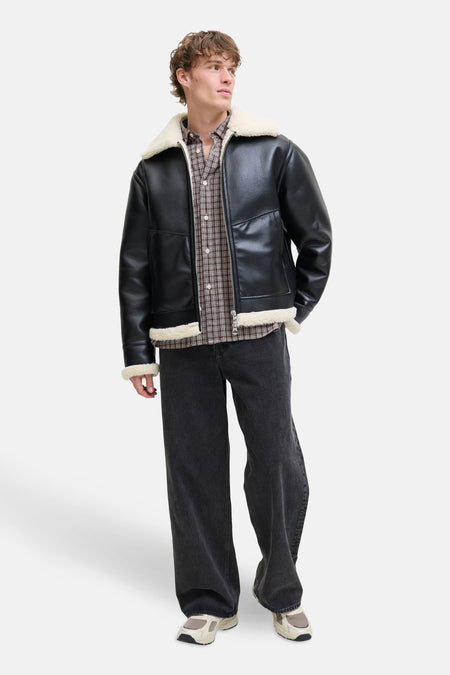 Rood geruit overhemd met lange mouwen van PREMIUM by JACK & JONES, gedragen met een zwart imitatielederen jasje en een wijde jeans.