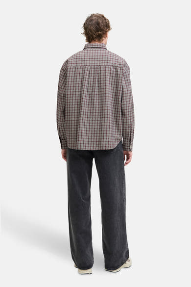 Rood geruit overhemd met lange mouwen van PREMIUM by JACK & JONES, gedragen met een wijde zwarte jeans.