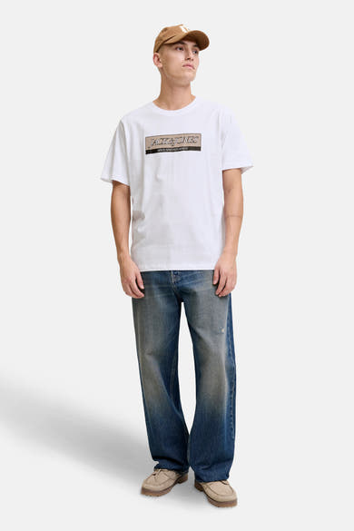 Wit T-shirt met korte mouwen van ORIGINALS BY JACK & JONES, gedragen met een wijde blauwe jeans en beige schoenen.