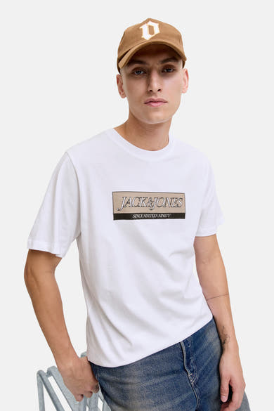 Wit T-shirt met korte mouwen van ORIGINALS BY JACK & JONES, met opgedrukte logo op de voorkant, gedragen met een blauwe jeans en een bruine pet