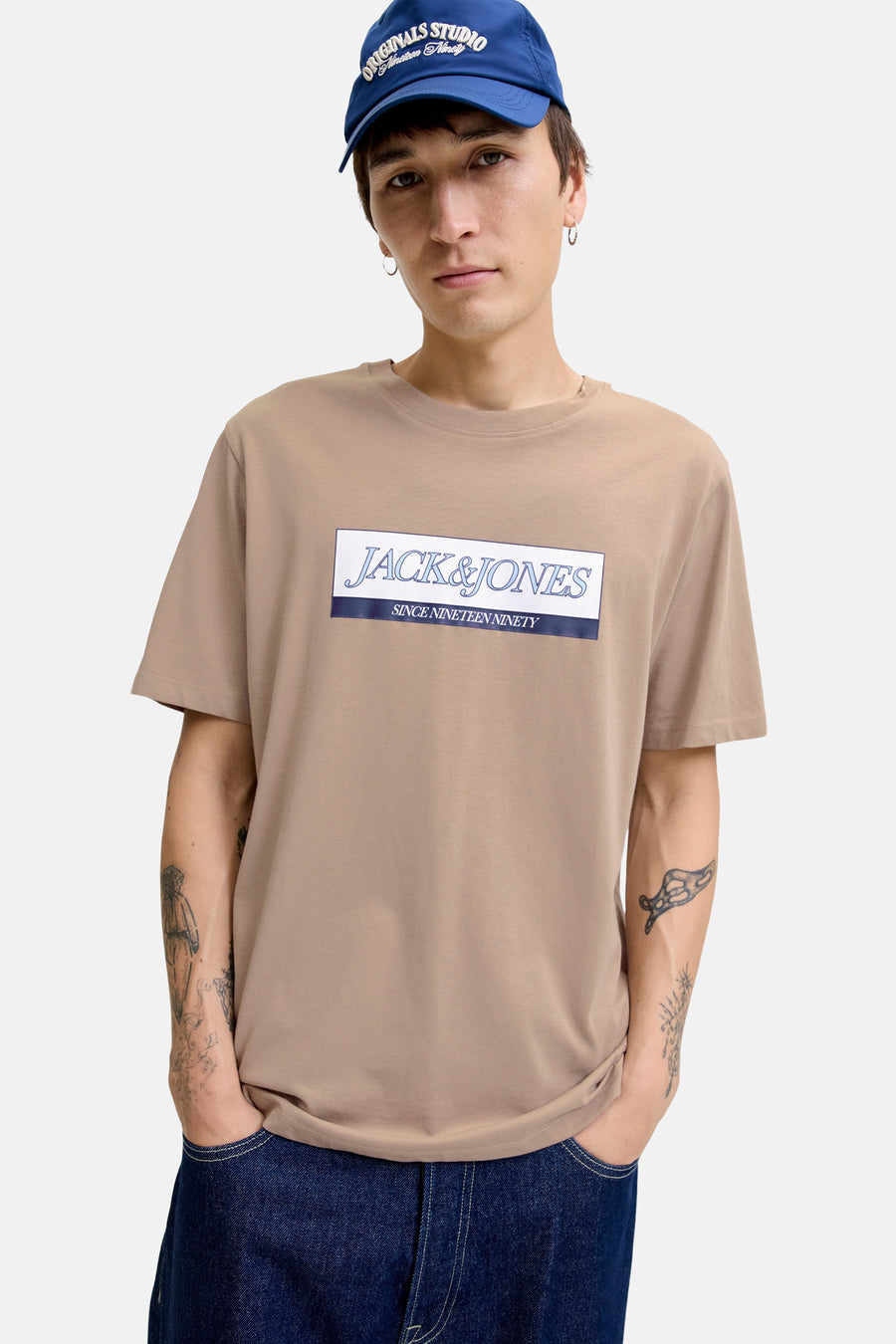 Beige T-shirt met korte mouwen van ORIGINALS BY JACK & JONES, met opdruk van het logo op de voorkant, gedragen met een spijkerbroek.
