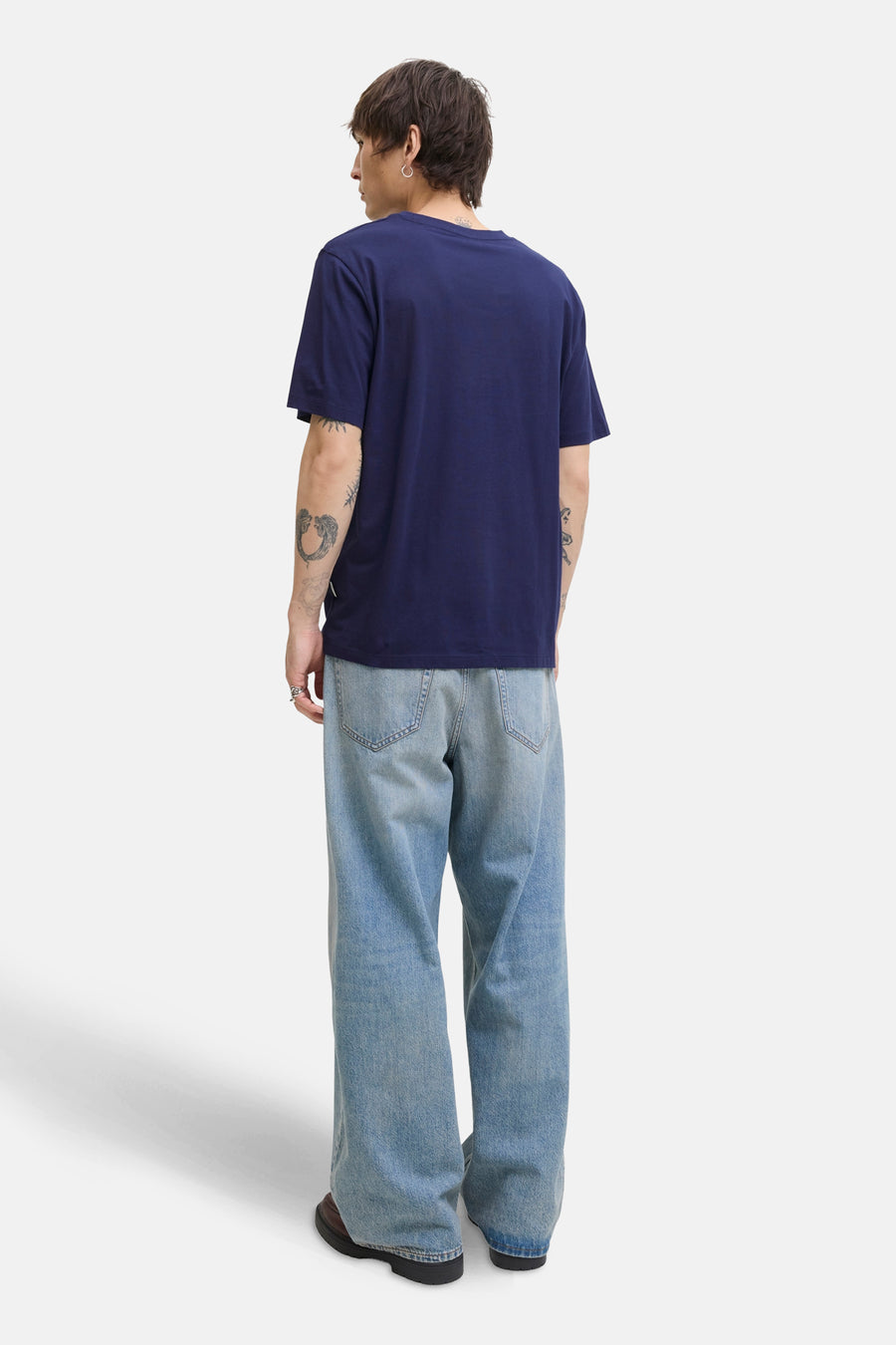Blauwe T-shirt met korte mouwen van ORIGINALS BY JACK & JONES, gedragen met een wijde jeans en tatoeages op de arm.