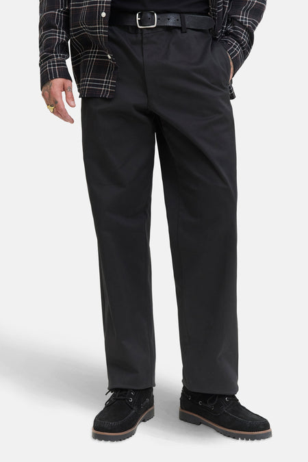 Chino noir de JACK & JONES JEANS INTELLIGENCE avec une chemise à carreaux et des chaussures bateau.