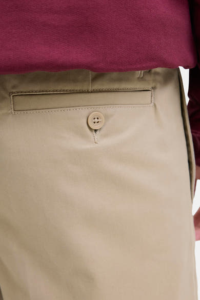 Beige chino broek van JACK & JONES JEANS INTELLIGENCE, met een achterzak met knoop en een bordeauxrode trui.