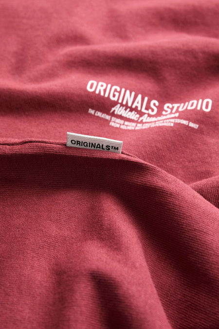 T-shirt bordeaux à manches courtes de PREMIUM by JACK & JONES, avec étiquette « Originals Studio » visible.