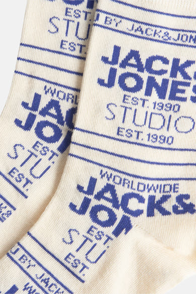 Paire de chaussettes écrues par ACCESSORIES BY JACK & JONES avec motif logo bleu sur toute la surface.
