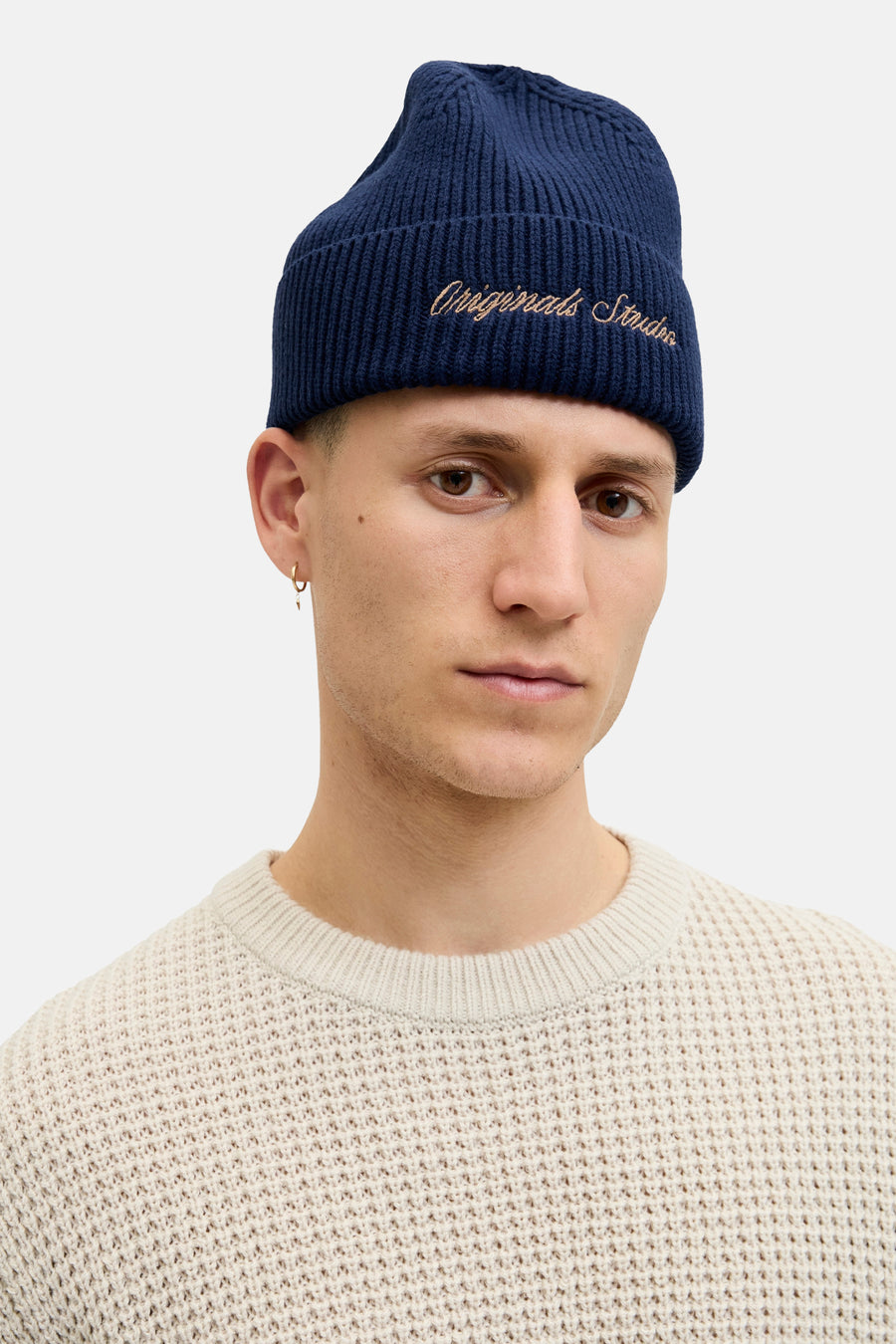 Bonnet bleu par ACCESSORIES BY JACK & JONES avec broderie décorative, porté avec un pull en maille texturée.