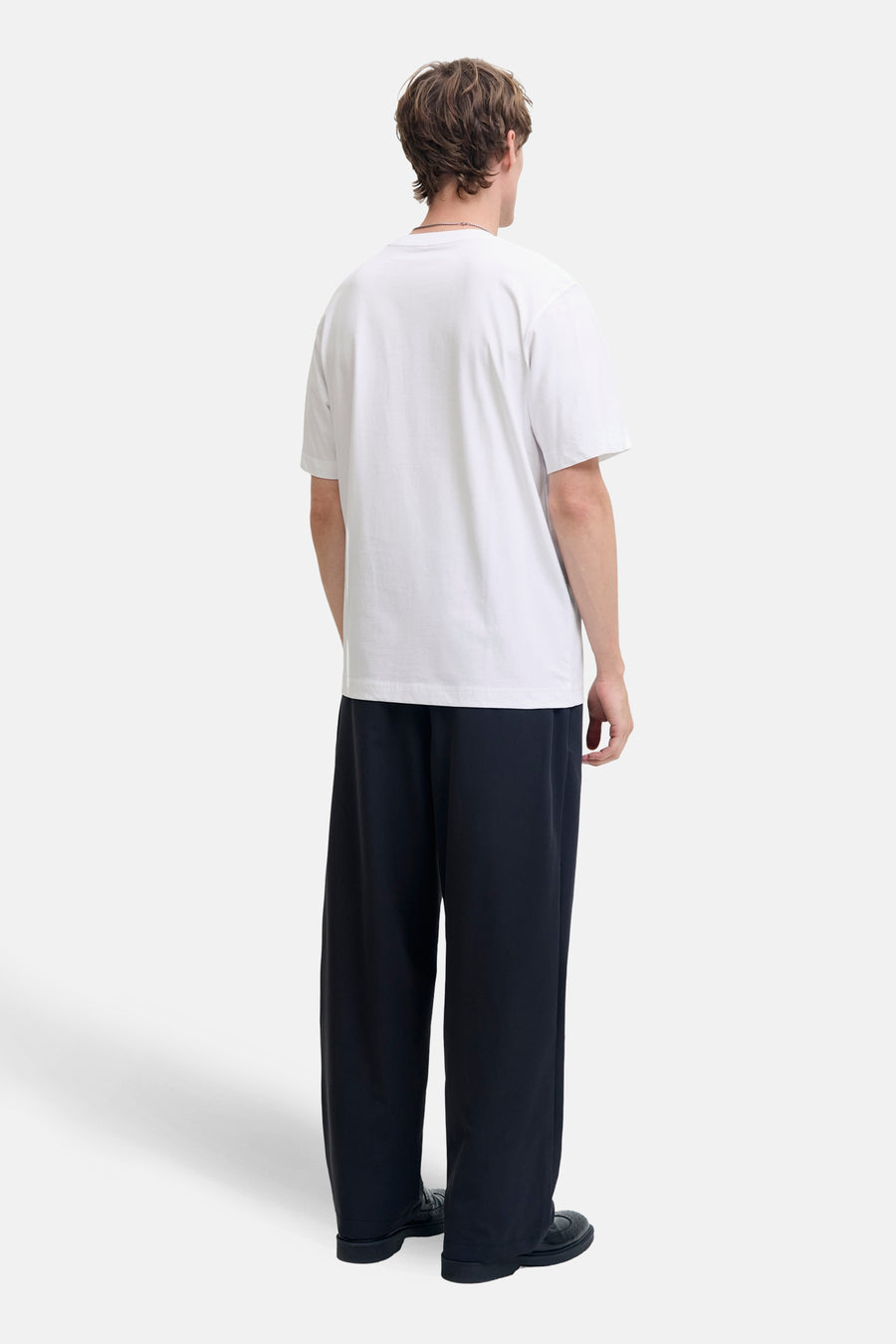 Wit T-shirt met korte mouwen van JACK & JONES, gedragen met een zwarte wijde broek.