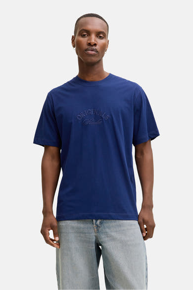 Blauw T-shirt met korte mouwen van JACK & JONES, gedragen met een geruit overhemd en een wijde jeans.