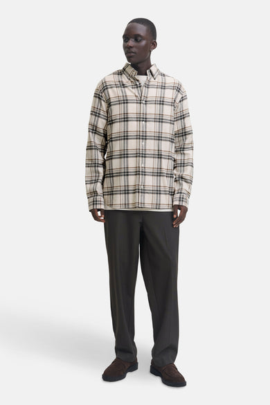 Chemise à manches longues beige à carreaux par JACK & JONES, portée avec un t-shirt blanc et un pantalon foncé.
