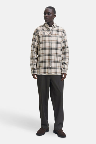 Chemise à manches longues beige à carreaux par JACK & JONES, portée avec un t-shirt blanc et un pantalon foncé.