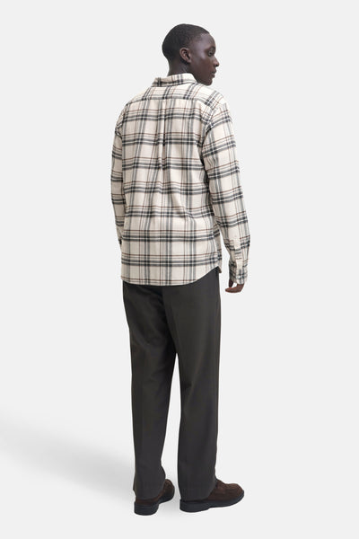 Chemise beige à carreaux à manches longues de JACK & JONES, avec pantalon sombre et chaussures marron.